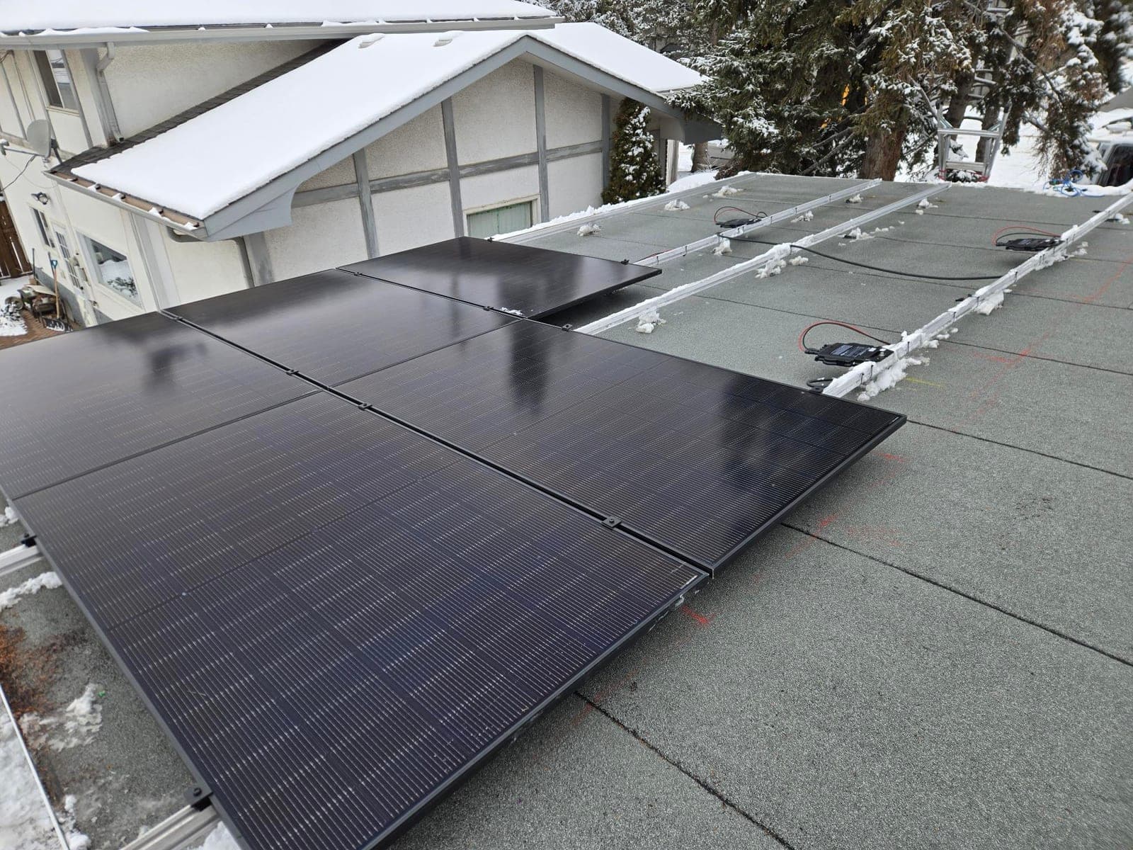 Six donated solar panels being installed as part of a larger array on a snowy Alberta roof, Solar Alberta Summer Auction 2025