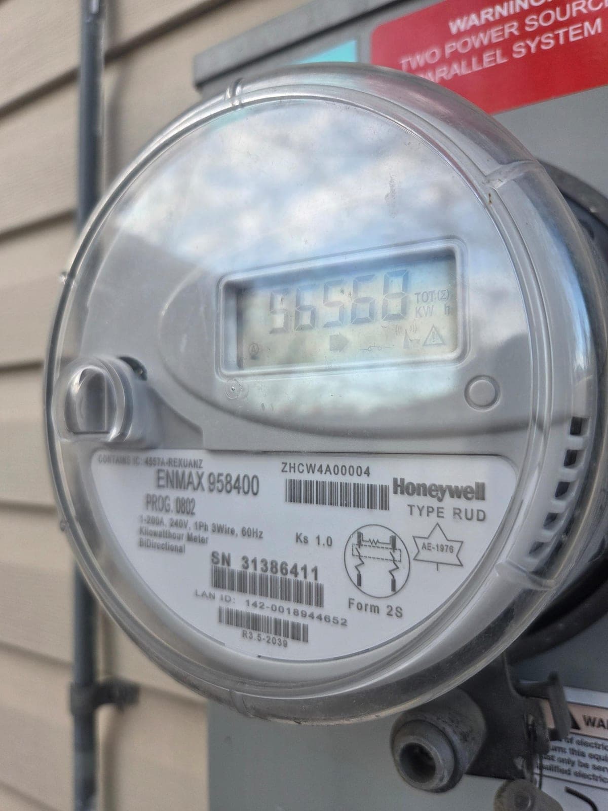 ENMAX bi-directional meter LCD showing 56558 TOT (Sigma) kWh with the right-pointing arrow lit at the bottom of the display, indicating cumulative kilowatt-hours delivered to the home from the grid.